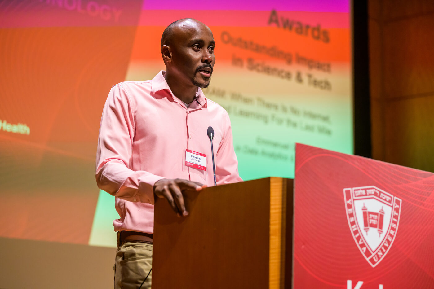 Emmanuel speaking at a podium